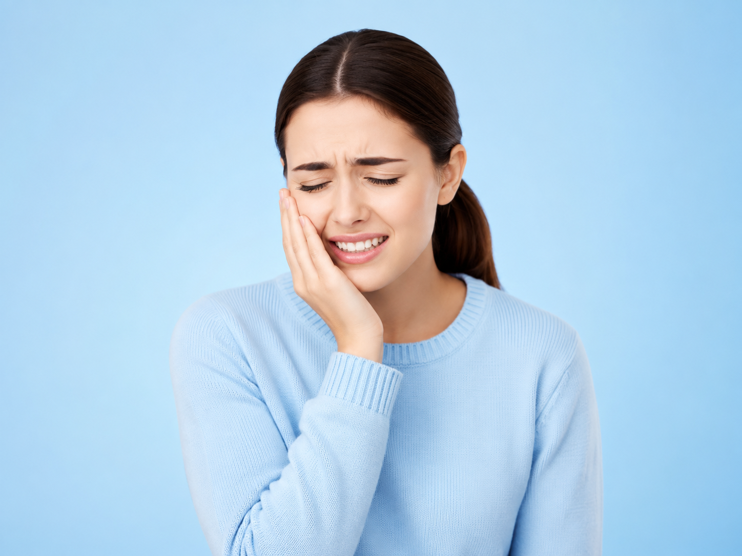 Woman holding her cheek due to gum discomfort